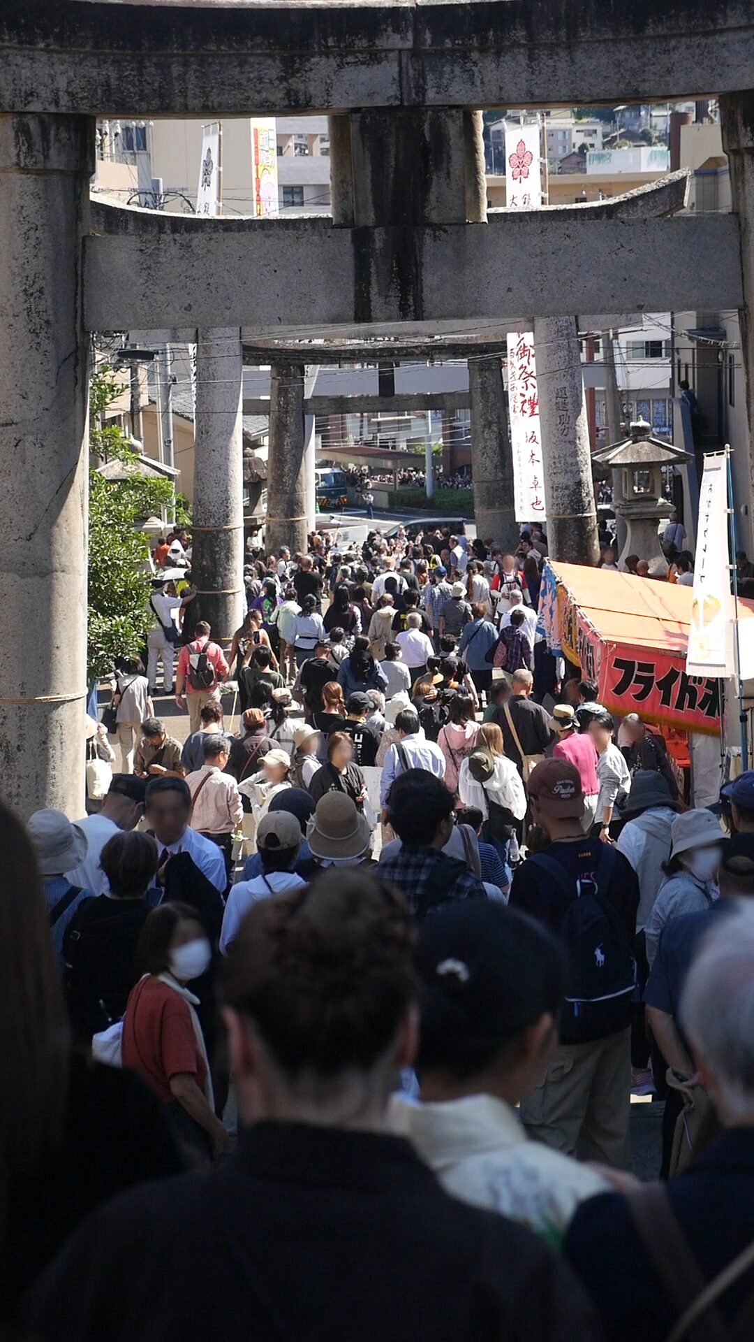 大勢の人が行き交う、鳥居の下の参道